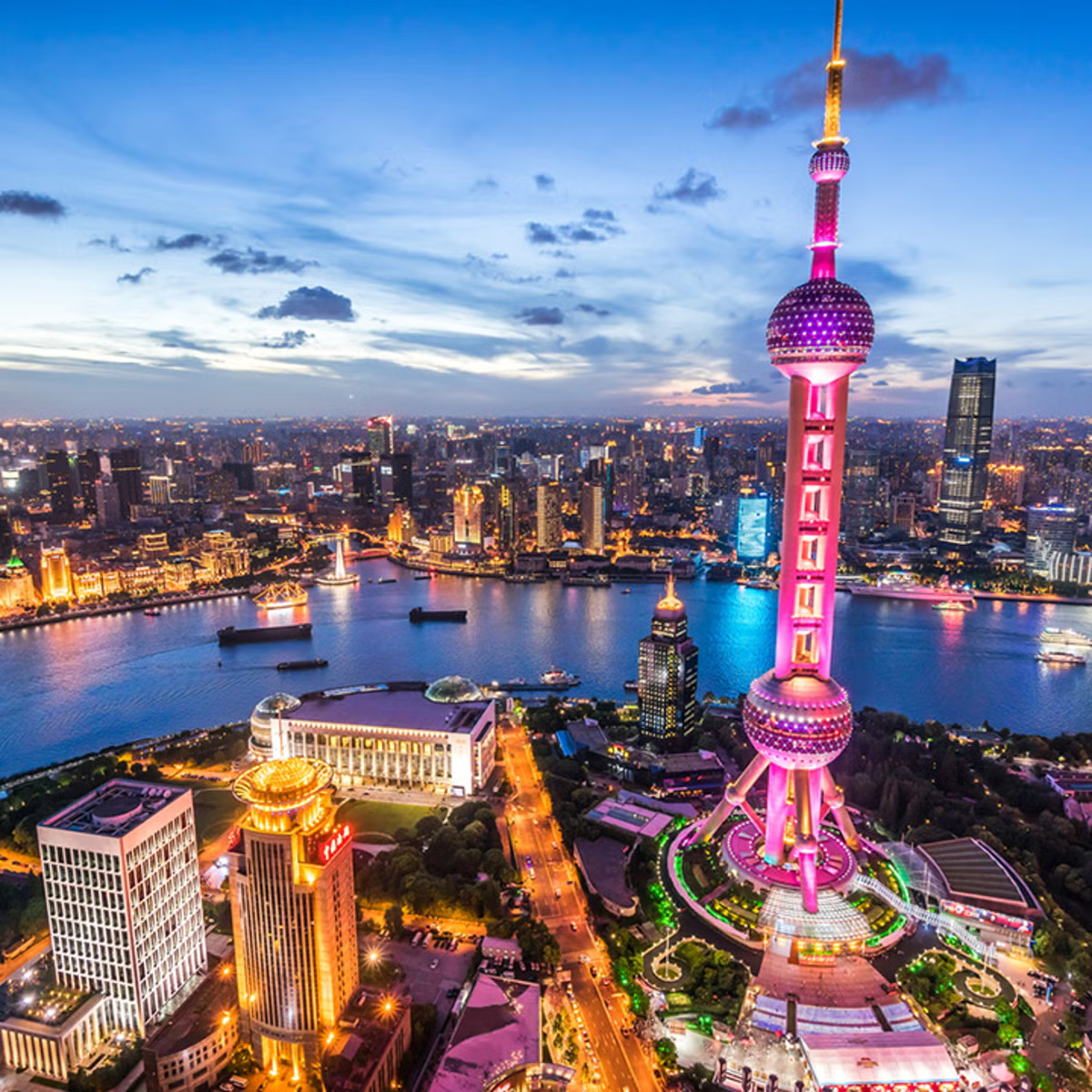 Vista aérea de Shanghái al atardecer con la Torre Perla Oriental iluminada